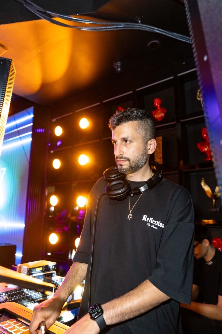 DJ Shlomi Shanti at the decks under warm lights